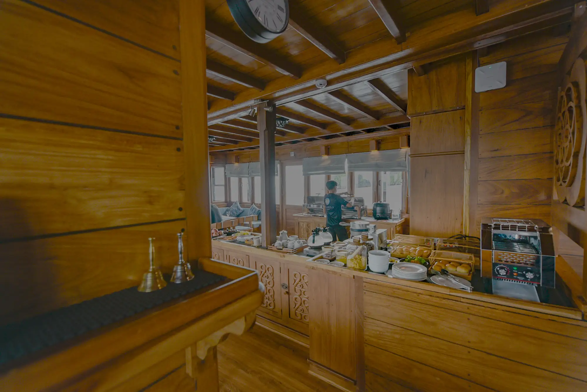 A crew member is preparing food at the indoor buffet of the Lotus Malaillo Liveaboard restaurant